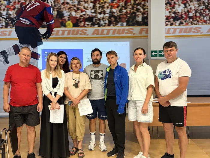 Групповое фото на фоне хоккейной арены